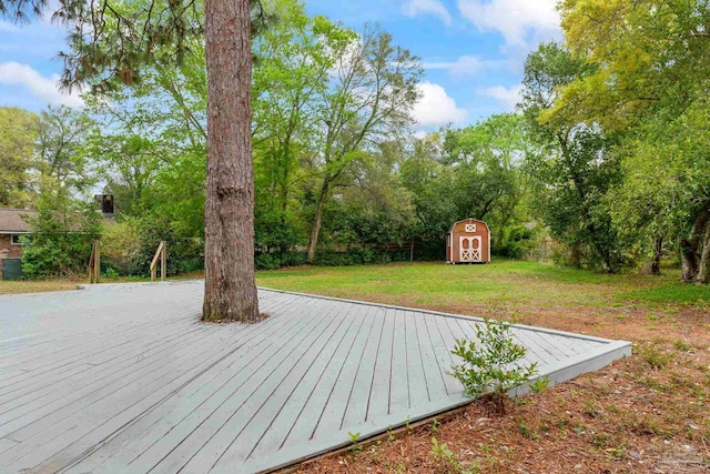 wooden deck with an outbuilding, a yard, and a shed