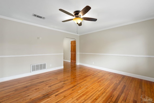 unfurnished room featuring light wood finished floors, baseboards, visible vents, and arched walkways