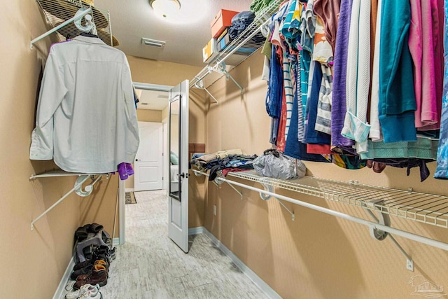 spacious closet with light hardwood / wood-style flooring