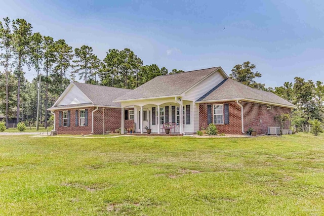 ranch-style home featuring a porch, central AC unit, and a front lawn