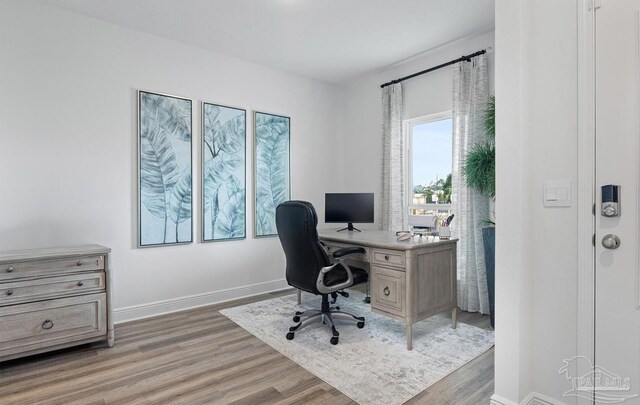 office area featuring baseboards and light wood-type flooring