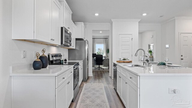 kitchen featuring white cabinetry, a sink, an island with sink, appliances with stainless steel finishes, and wood finished floors