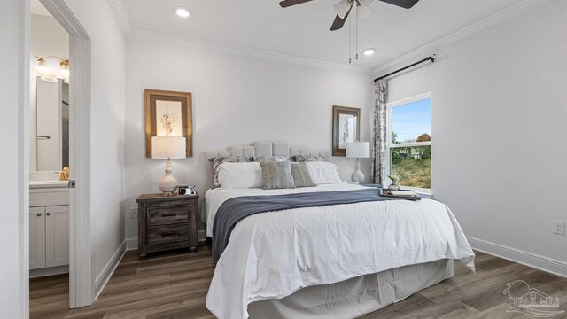 bedroom with ornamental molding, connected bathroom, baseboards, and wood finished floors