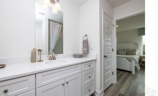 bathroom featuring ensuite bathroom, visible vents, wood finished floors, and vanity
