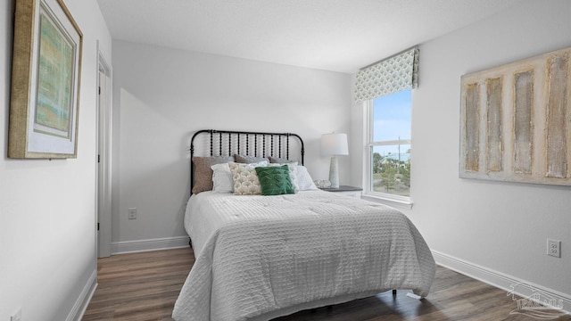 bedroom featuring baseboards and wood finished floors
