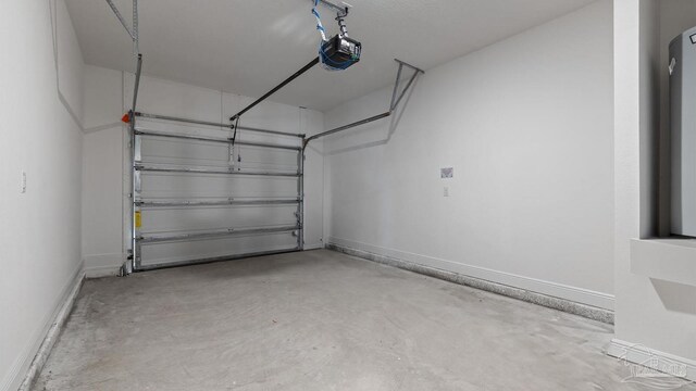garage featuring a garage door opener and baseboards