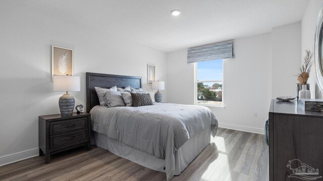 bedroom featuring baseboards and wood finished floors
