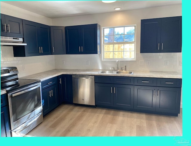 kitchen with light wood-type flooring, backsplash, stainless steel appliances, exhaust hood, and sink