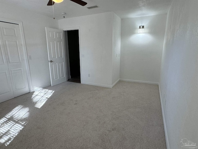 carpeted spare room featuring ceiling fan