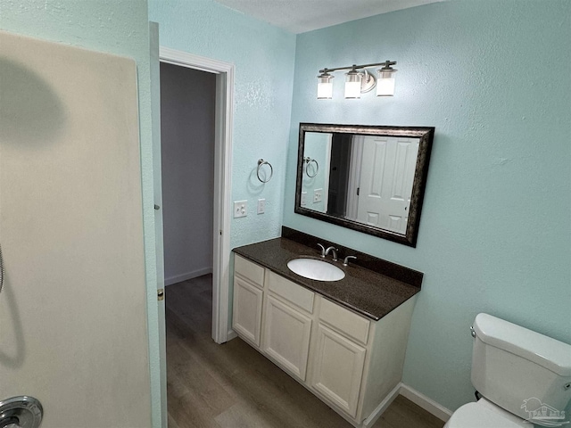 bathroom with hardwood / wood-style floors, vanity, and toilet