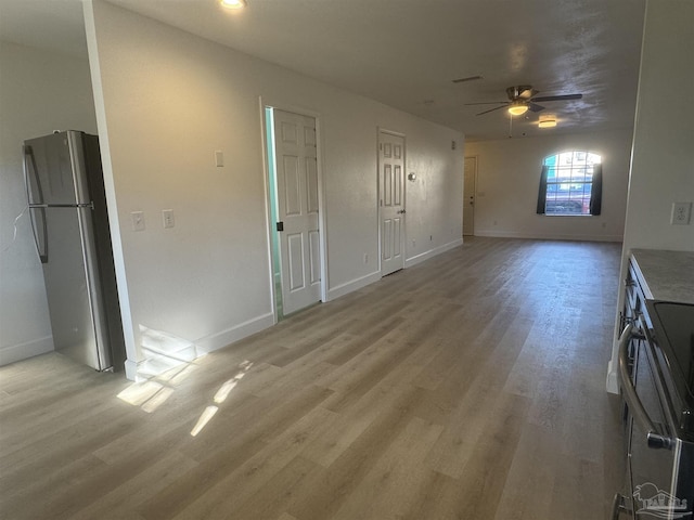 unfurnished living room featuring ceiling fan and light hardwood / wood-style floors