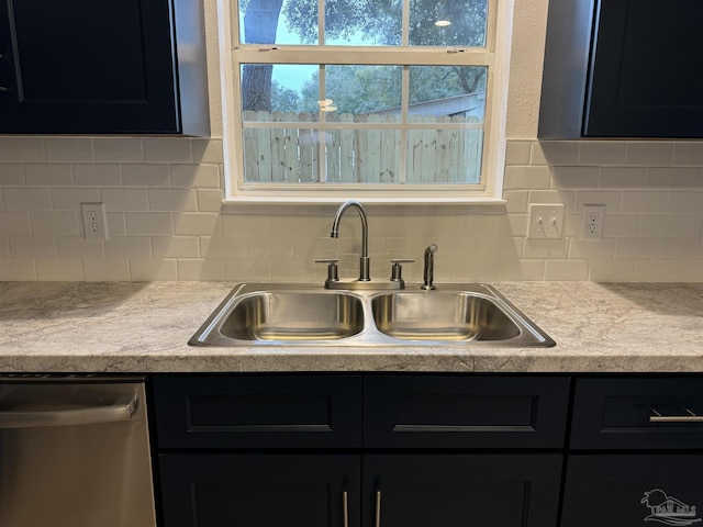 kitchen with stainless steel dishwasher, sink, and tasteful backsplash