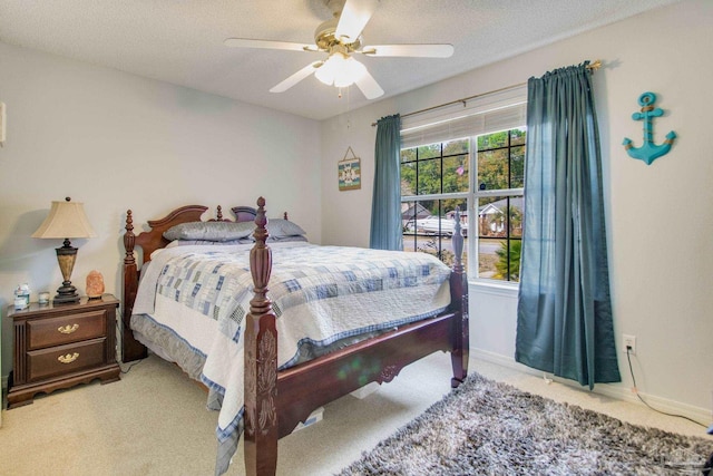 carpeted bedroom with a textured ceiling and ceiling fan