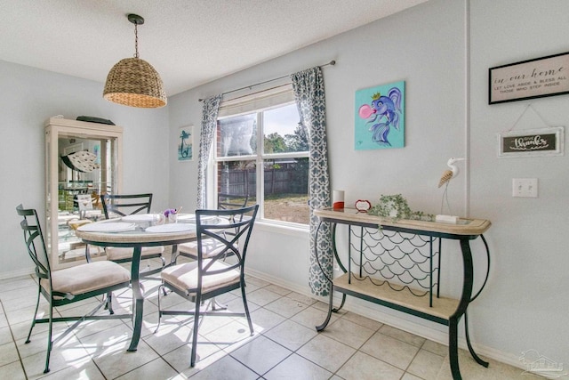 dining space featuring light tile patterned flooring and a textured ceiling