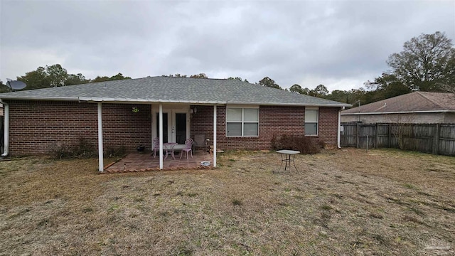 rear view of property with a patio area and a lawn