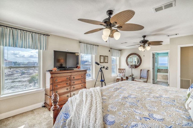 tiled bedroom featuring ceiling fan, baseboards, visible vents, and a textured ceiling