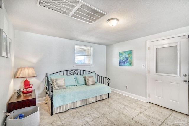 bedroom with visible vents, a textured ceiling, and baseboards