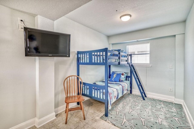 bedroom featuring baseboards and a textured ceiling