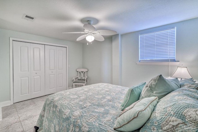 tiled bedroom with visible vents, baseboards, a closet, and ceiling fan