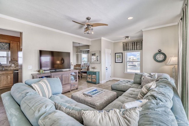 living room with plenty of natural light, ornamental molding, and a ceiling fan