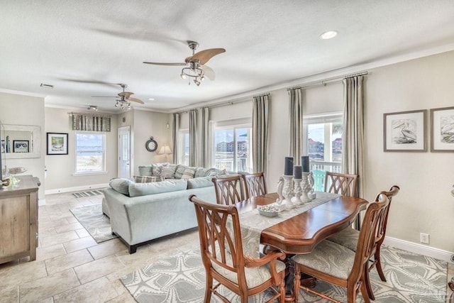 dining space featuring a wealth of natural light, baseboards, a ceiling fan, and ornamental molding