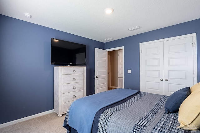 bedroom featuring a closet, carpet, and a textured ceiling