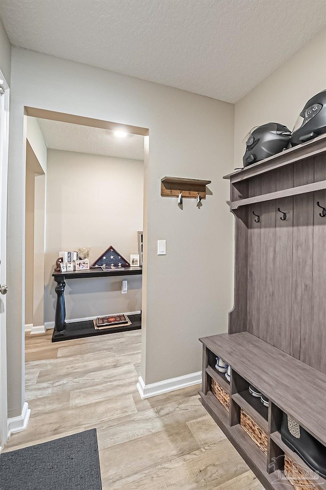 mudroom with light hardwood / wood-style flooring and a textured ceiling