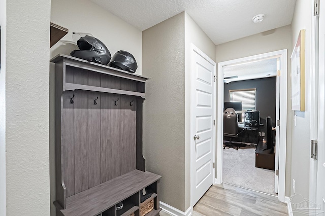 mudroom featuring light hardwood / wood-style flooring and a textured ceiling