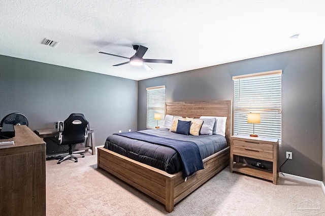 bedroom with light carpet, a textured ceiling, and ceiling fan