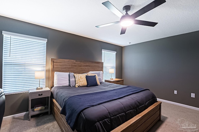 carpeted bedroom featuring ceiling fan and a textured ceiling