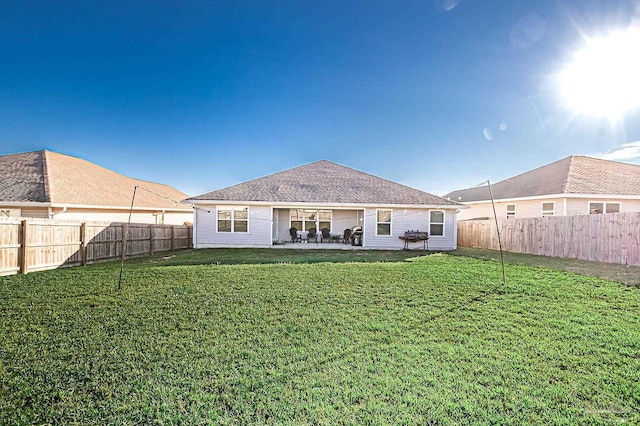 rear view of house with a lawn and a patio