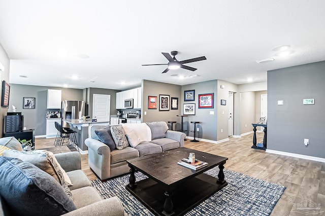 living room featuring light hardwood / wood-style floors and ceiling fan