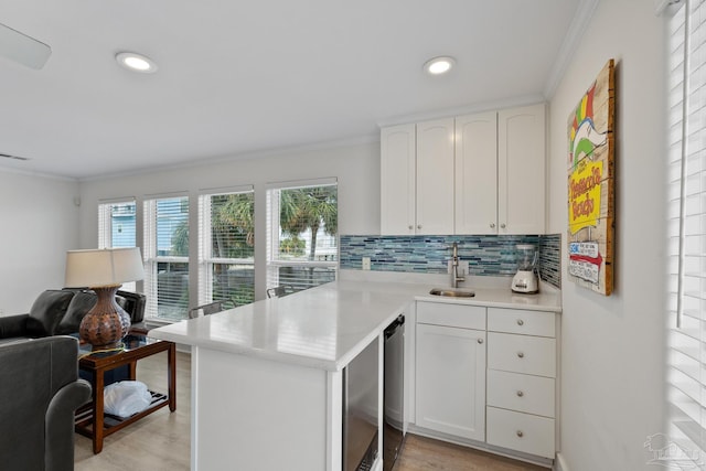 kitchen featuring white cabinets, crown molding, sink, decorative backsplash, and kitchen peninsula