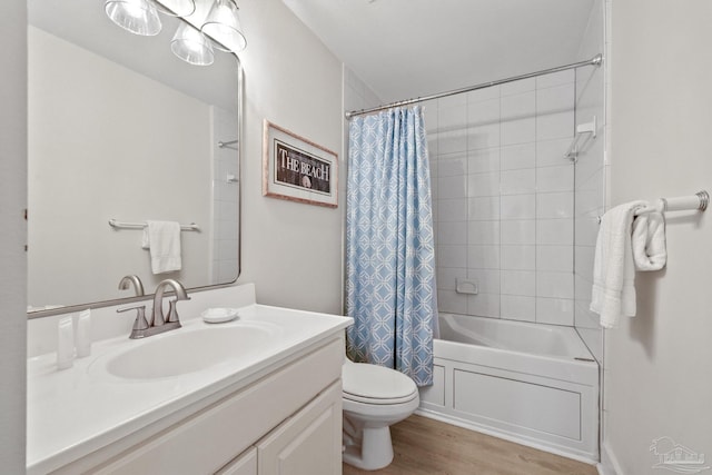 full bathroom with hardwood / wood-style floors, vanity, shower / tub combo with curtain, and toilet