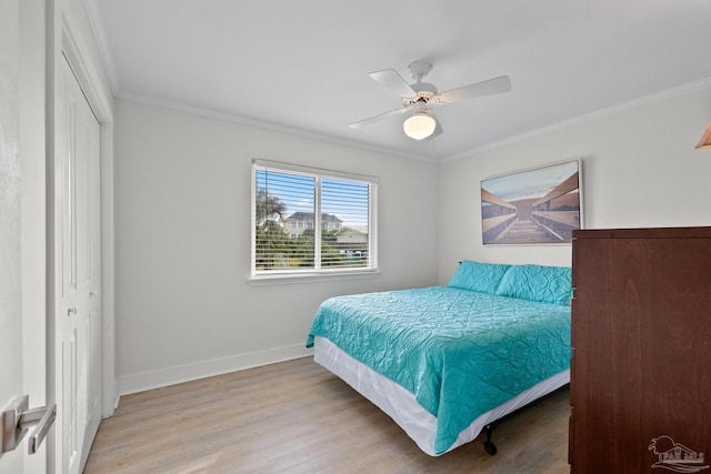 bedroom featuring light wood-type flooring, a closet, crown molding, and ceiling fan