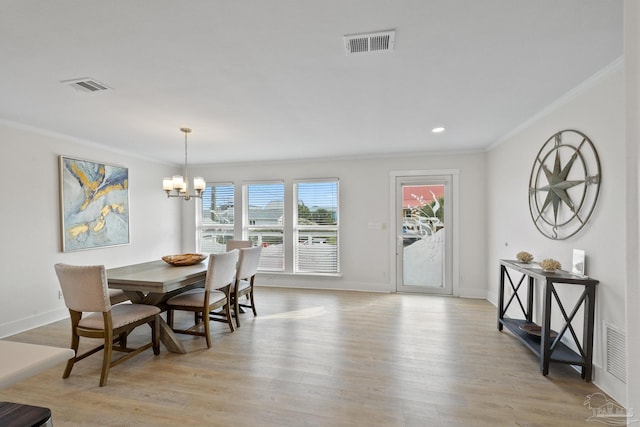 dining area featuring a chandelier, light wood-type flooring, and ornamental molding