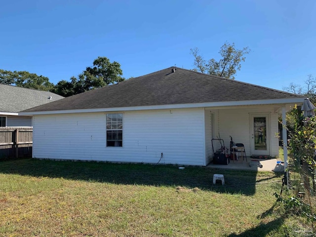 rear view of property featuring a patio and a lawn