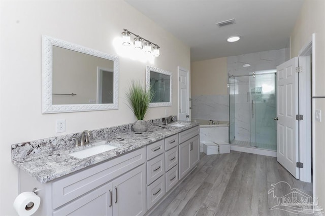 bathroom featuring plus walk in shower, hardwood / wood-style floors, and vanity