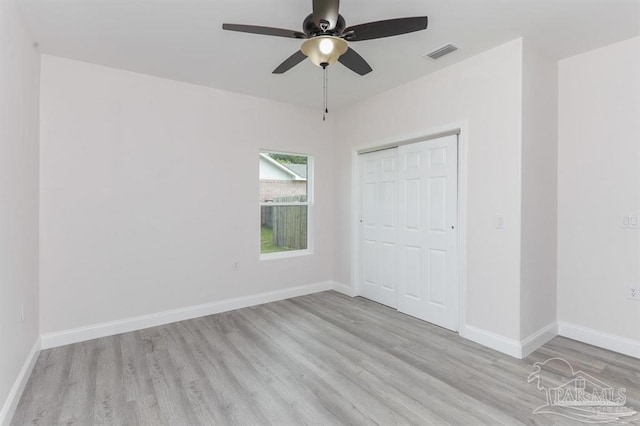 unfurnished bedroom featuring ceiling fan, a closet, and light wood-type flooring