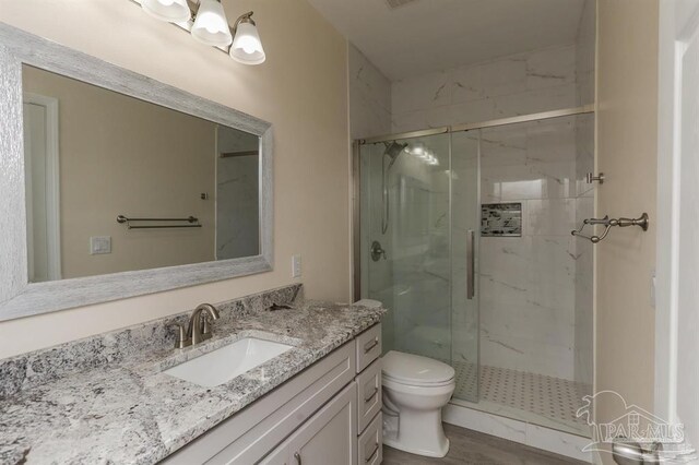 bathroom featuring vanity, toilet, and a shower with shower door