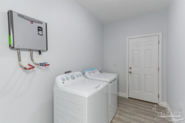 laundry area featuring light hardwood / wood-style floors, separate washer and dryer, and water heater