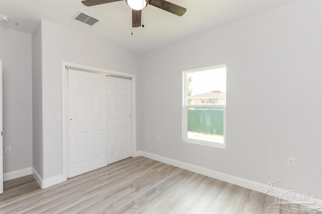 unfurnished bedroom featuring ceiling fan, light wood-type flooring, and a closet