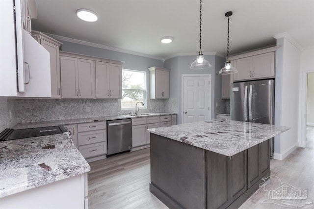 kitchen featuring pendant lighting, a center island, backsplash, ornamental molding, and stainless steel appliances