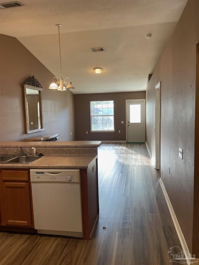 kitchen featuring sink, dark wood-type flooring, white dishwasher, vaulted ceiling, and a chandelier