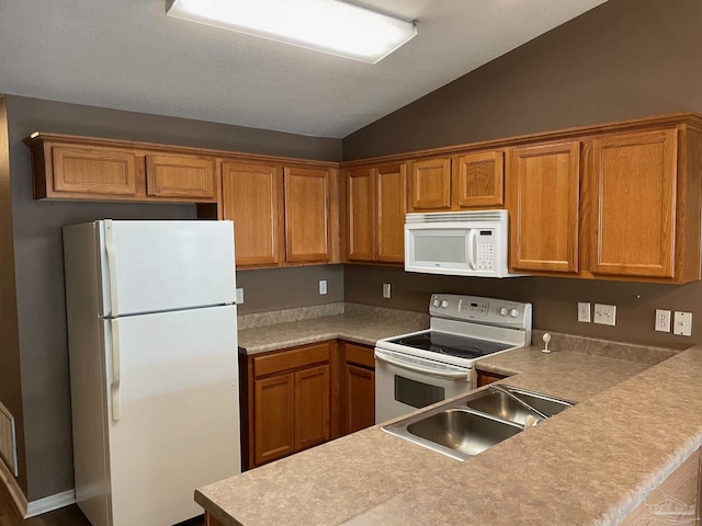 kitchen featuring vaulted ceiling, hardwood / wood-style floors, sink, kitchen peninsula, and white appliances