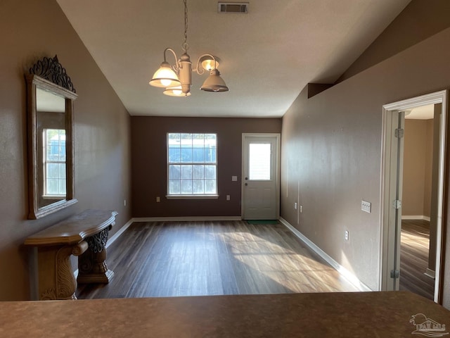 foyer featuring vaulted ceiling, a chandelier, and wood-type flooring