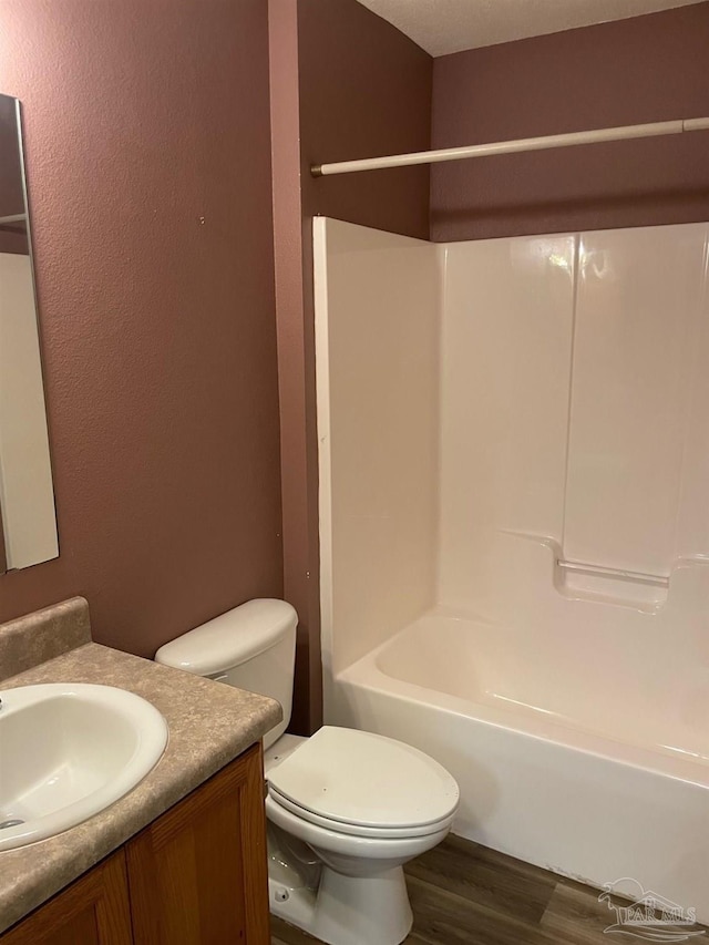 full bathroom featuring hardwood / wood-style flooring, shower / bathtub combination, vanity, and toilet