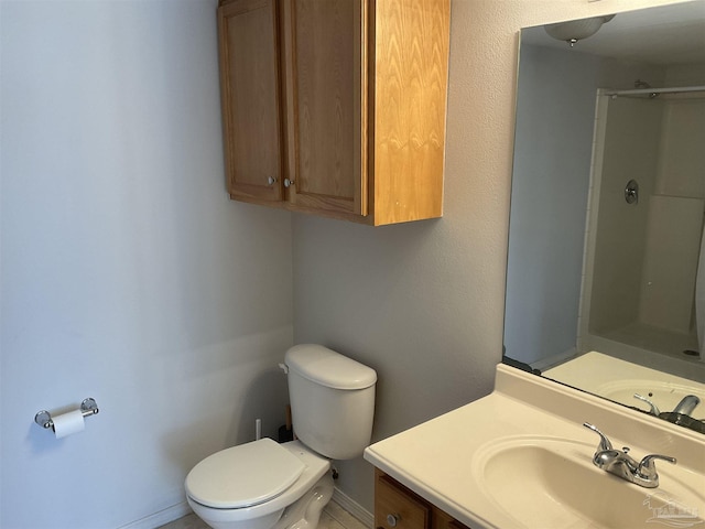 bathroom featuring vanity, a shower with door, and toilet