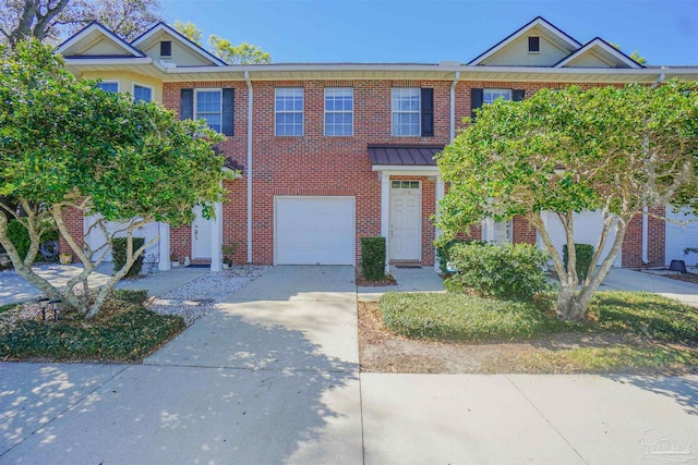 multi unit property featuring a garage, concrete driveway, and brick siding