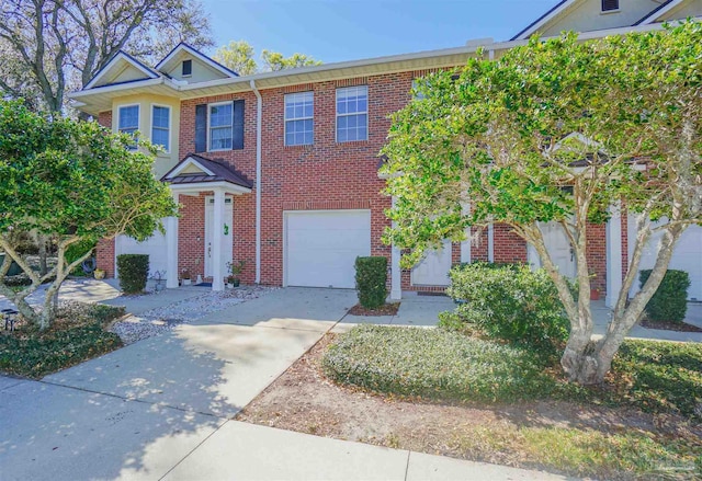 multi unit property featuring concrete driveway, brick siding, and an attached garage